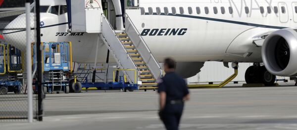Um trabalhador caminha ao lado de um avião Boeing 737 MAX 8 estacionado. - Sputnik Brasil