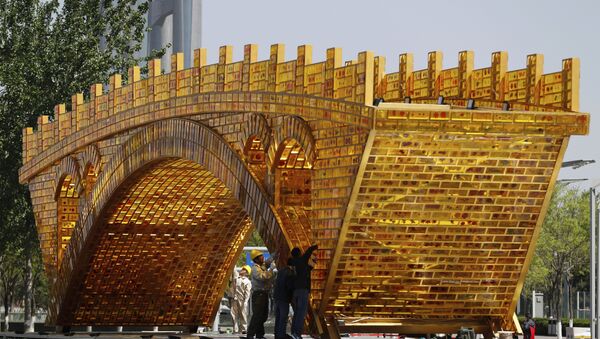 Workers install wires on a 'Golden Bridge of Silk Road' structure on a platform outside the National Convention Center, the venue which will hold the Belt and Road Forum for International Cooperation, in Beijing - Sputnik Brasil