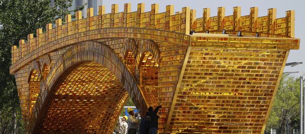Workers install wires on a 'Golden Bridge of Silk Road' structure on a platform outside the National Convention Center, the venue which will hold the Belt and Road Forum for International Cooperation, in Beijing Workers install wires on a 'Golden Bridge of Silk Road' structure on a platform outside the National Convention Center, the venue which will hold the Belt and Road Forum for International Cooperation, in Beijing - Sputnik Brasil