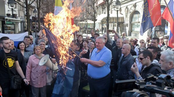 Vojislav Seselj, líder do Partido Radical Sérvio, segura bandeira da OTAN em chamas durante manifestação em Belgrado - Sputnik Brasil