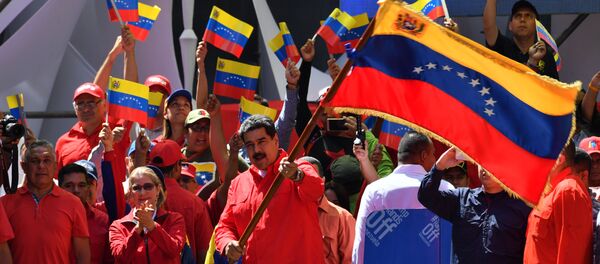O presidente venezuelano Nicolás Maduro agita a bandeira nacional durante uma marcha pró-governamental em Caracas, em 23 de fevereiro de 2019. - Sputnik Brasil