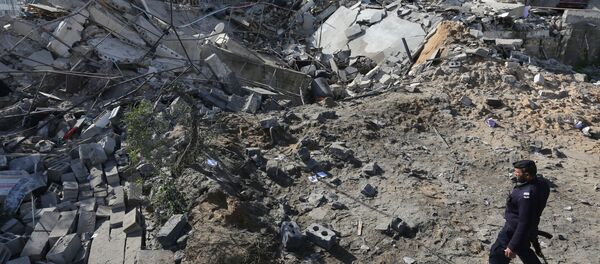 Policial do Hamas perto dos escombros de um prédio após o ataque israelense contra a cidade de Gaza - Sputnik Brasil