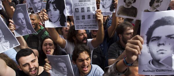 Ativistas seguram fotos de desaparecidos durante regime militar brasileiro em frente a um clube militar no Centro do Rio de Janeiro, 29 de março de 2012 - Sputnik Brasil