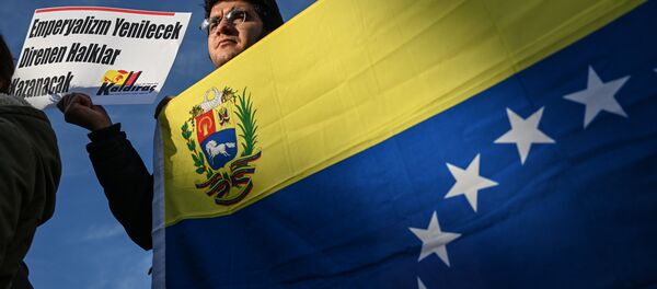 Um ativista de esquerda turco segura uma bandeira nacional venezuelana e um cartaz que se traduz como O imperialismo perderá, o povo resistente vencerá - Sputnik Brasil