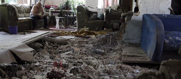 Morador de casa atingida por bombardeio em Donetsk - Sputnik Brasil