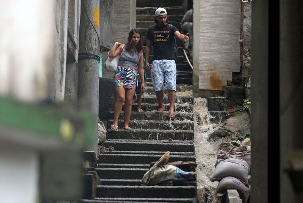 Pessoas descem as escadas em área alagada no Rio de Janeiro - Sputnik Brasil
