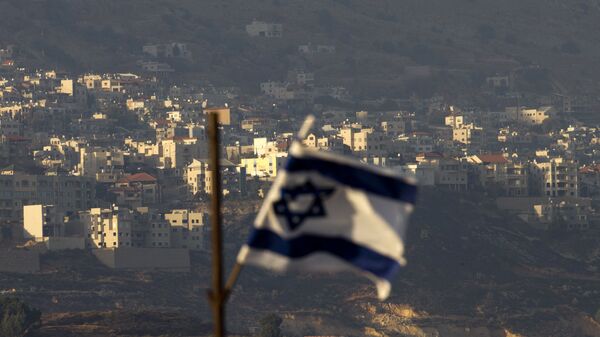 Uma bandeira israelense em frente à aldeia de Majdal Shams nas colinas de Golã controladas por Israel. - Sputnik Brasil