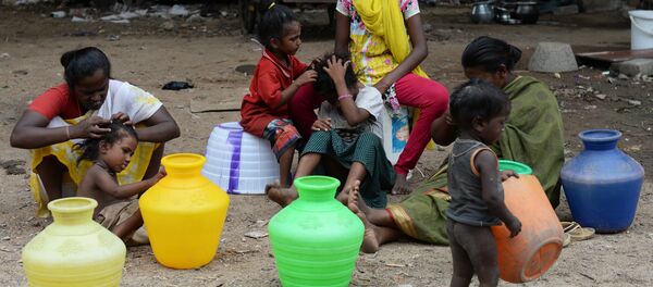 Mulheres sem-teto na Índia sob um ponte com suas crianças aguardam para coletar água em um caminhão de distribuição em Chennai, em 8 de junho de 2017. Mulheres sem-teto na Índia sob um ponte com suas crianças aguardam para coletar água em um caminhão de distribuição em Chennai, em 8 de junho de 2017. - Sputnik Brasil