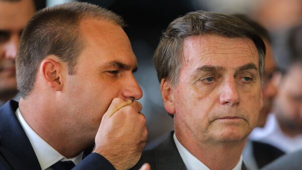 Eduardo Bolsonaro cochicha no ouvido do pai Jair Bolsonaro no comitê de transição de governo em Brasília, 14 de novembro de 2018 - Sputnik Brasil