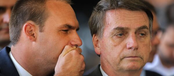 Eduardo Bolsonaro cochicha no ouvido do pai Jair Bolsonaro no comitê de transição de governo em Brasília, 14 de novembro de 2018 - Sputnik Brasil