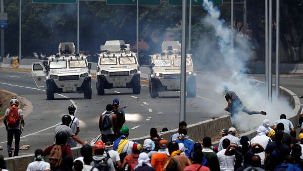 Veículos blindados das Forças Armadas da Venezuela se aproximam dos manifestantes perto da base aérea La Carlota, em Caracas - Sputnik Brasil