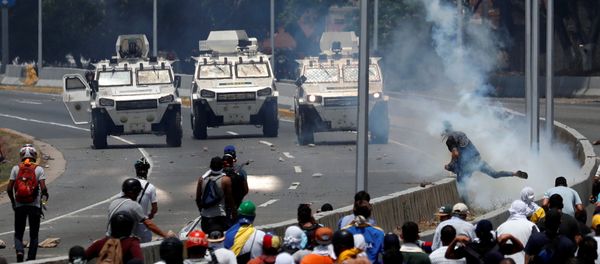 Veículos blindados das Forças Armadas da Venezuela se aproximam dos manifestantes perto da base aérea La Carlota, em Caracas Veículos blindados das Forças Armadas da Venezuela se aproximam dos manifestantes perto da base aérea La Carlota, em Caracas - Sputnik Brasil