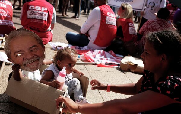 Filha de um sindicalista segura uma máscara representando o ex-presidente Luiz Inácio Lula da Silva durante uma manifestação do Dia do Trabalho em São Paulo, Brasil, em 1º de maio de 2019. - Sputnik Brasil