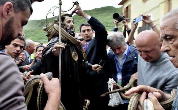 Pessoas retirando suas cobras da estátua de São Domingos de Gusmão durante a celebração do festival anual dos Serpari nas ruas da vila italiana de Cocullo - Sputnik Brasil