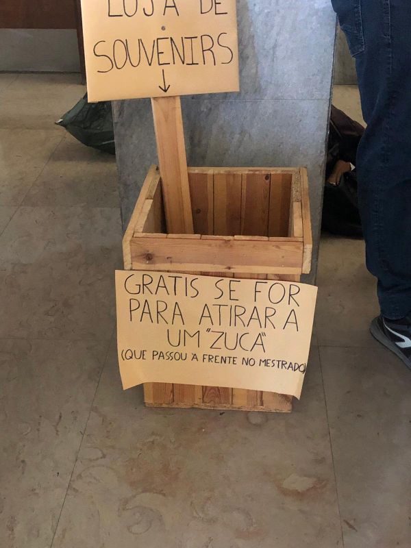 Caixa com pedras no hall do edifício da Faculdade de Direito da Universidade de Lisboa, sinalizada com placas onde se lia Loja de souvenirs. Grátis se for para atirar a um zuca que passou à frente no mestrado - Sputnik Brasil