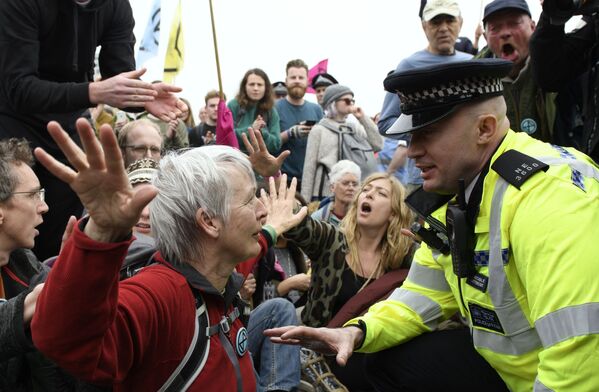 Policial fala com uma ativista do grupo ambientalista Extinction Rebellion durante protestos em Londres - Sputnik Brasil