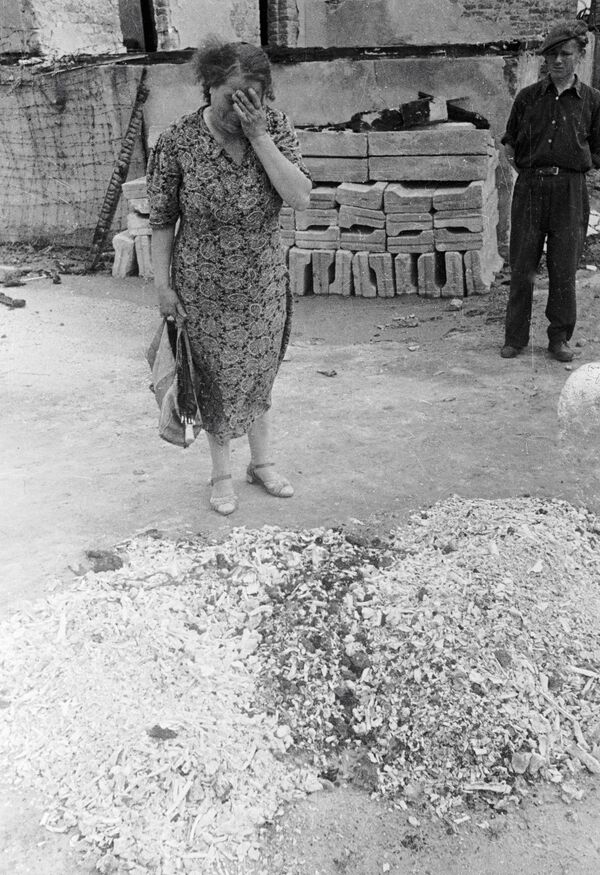Mulher chora sobre cinzas de pessoas queimadas no campo de concentração alemão nazista Majdanek, Polônia - Sputnik Brasil