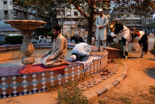 Homens fazem as orações da noite ao lado de uma fonte depois de quebrar o jejum (iftar) no Ramadã, em Karachi, Paquistão, 8 de maio de 2019. - Sputnik Brasil