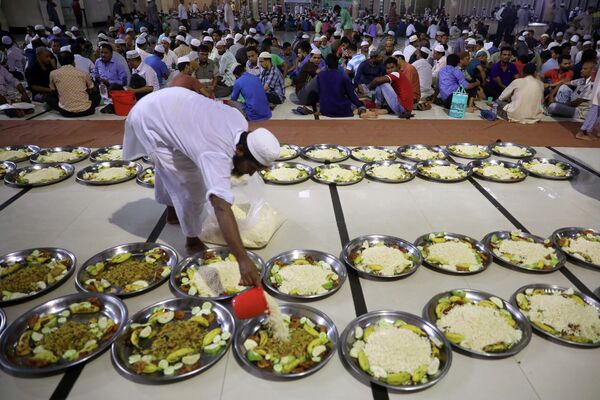 Um voluntário organiza pratos de comida na mesquita nacional de Baitul Mokarram para os muçulmanos quebrarem o jejum rapidamente durante o do Ramadã em Dhaka, Bangladesh, 8 de maio de 2019. - Sputnik Brasil