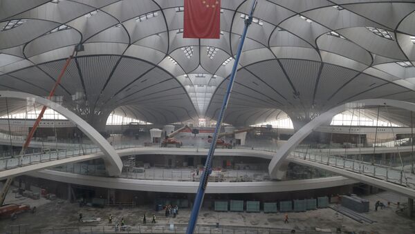 A bandeira nacional da China tremula pendurada no terminal do Aeroporto Internacional de Pequim Daxing, que está sob construção. - Sputnik Brasil