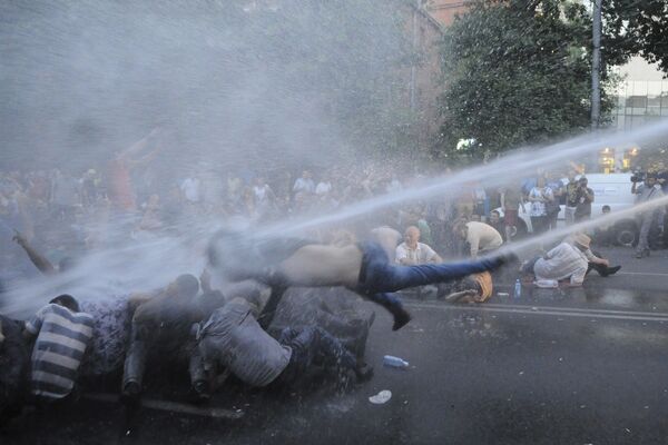 Manifestantes atingidos por um jato de água lançado de um veículo de polícia durante o protesto contra o aumento das tarifas de energia em Erevan, capital da Armênia, em 22 de junho de 2015. - Sputnik Brasil