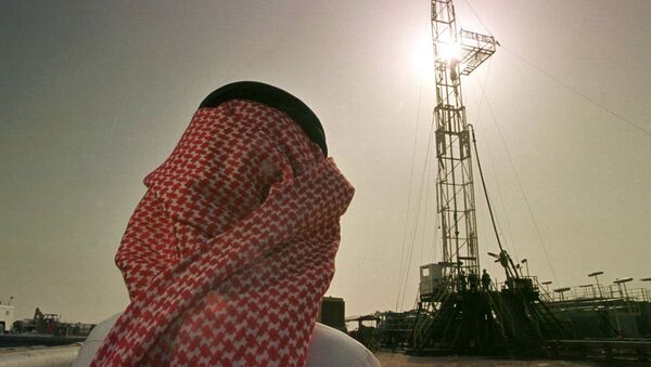 Um funcionário da companhia de petróleo saudita Aramco observa uma plataforma no campo de petróleo de al-Howta. - Sputnik Brasil