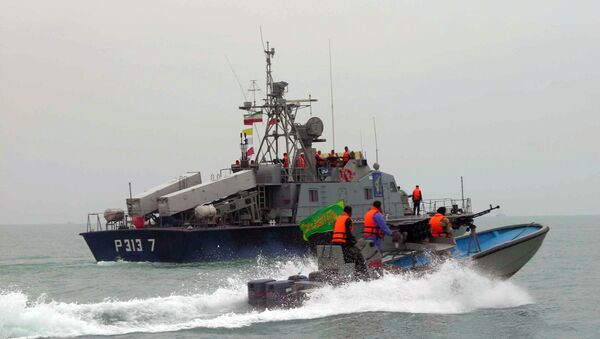 Membros da Guarda Revolucionária Irã navegam junto a uma embarcação iraniana durante manobras ao longo do mar do Golfo e do mar de Omã. - Sputnik Brasil