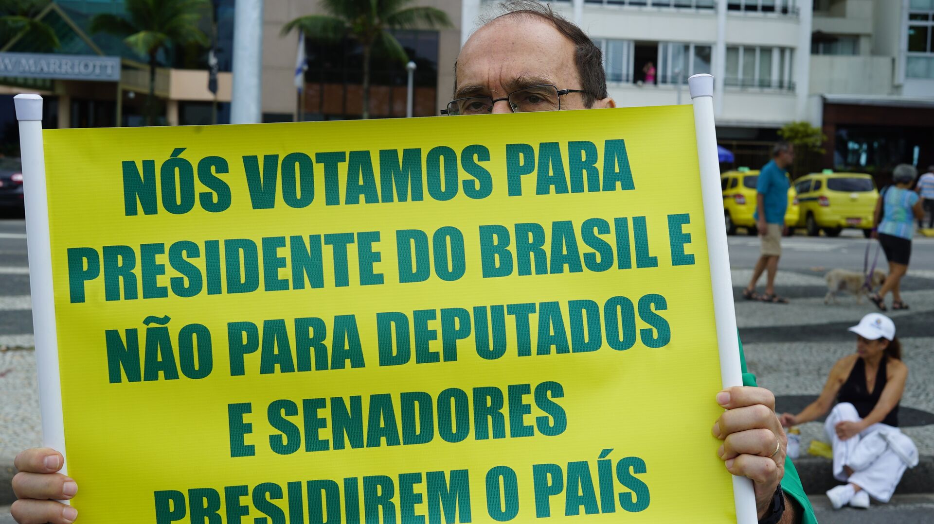 Apoiador do presidente Jair Bolsonaro carrega cartaz com críticas ao Congresso. - Sputnik Brasil, 1920, 06.12.2021