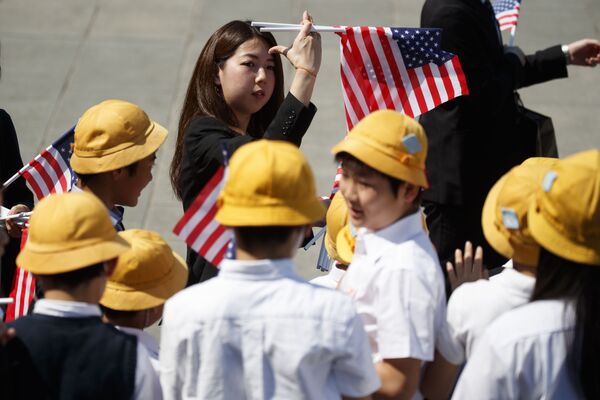 Estudantes japoneses com bandeiras americanas se preparando para a chegada de Trump ao Palácio Imperial em Tóquio - Sputnik Brasil