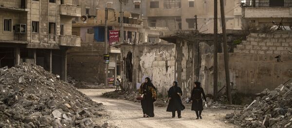 Mulheres caminham em meio a ruínas em Raqqa, cidade localizada no norte da Síria, 1º de maio de 2019 - Sputnik Brasil