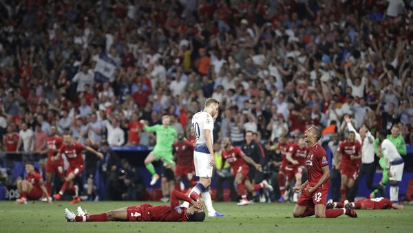 Tottenham's Harry Kane walks past Liverpool's players as they celebrate after winning the Champions League final soccer match against Tottenham Hotspur at the Wanda Metropolitano Stadium in Madrid, Saturday, June 1, 2019. - Sputnik Brasil