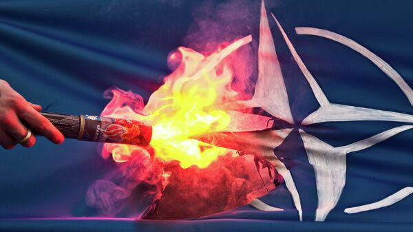 Bandeira da OTAN é queimada durante protestos - Sputnik Brasil