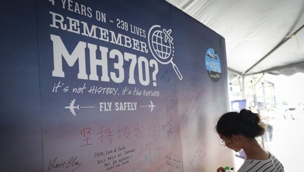 Uma mulher escreve condolências no Dia da Memória dos trágicos acontecimentos com o avião MH370 em Kuala Lumpur - Sputnik Brasil