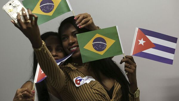 Médicas cubanas seguram bandeiras do Brasil e de Cuba no aeroporto de Brasília antes de voltarem para seu país de origem, em 22 de novembro de 2018. - Sputnik Brasil