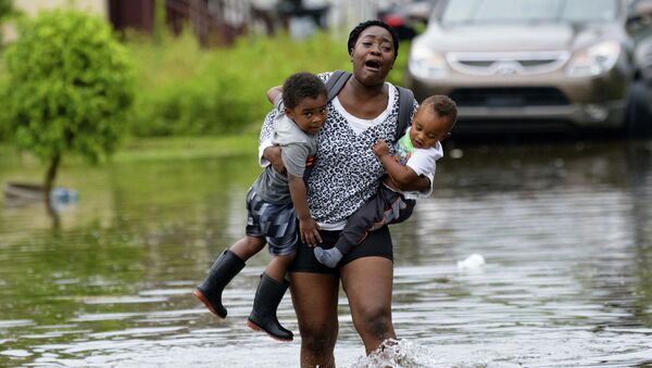 Mãe carregando seus filhos durante a inundação em Nova Orleans (EUA) - Sputnik Brasil
