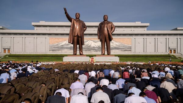 Moradores da cidade de Pyongyang (Coreia do Norte) durante um minuto de silêncio perto do monumento aos líderes norte-coreanos Kim Il-sung e Kim Jong-il, no 25º aniversário da morte de Kim Il-sung - Sputnik Brasil