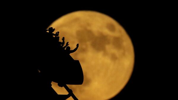 Silhuetas de pessoas em montanha russa com a Lua em fundo no parque de diversões Worlds of Fun, nos EUA - Sputnik Brasil