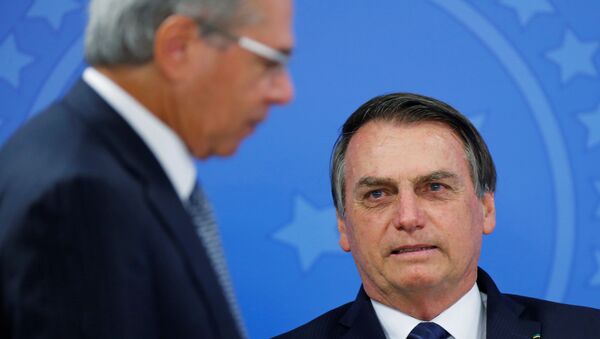 O ministro da Economia, Paulo Guedes, passa em frente ao presidente do Brasil, Jair Bolsonaro (PSL) no Palácio do Planalto em 16 de julho de 2019. - Sputnik Brasil