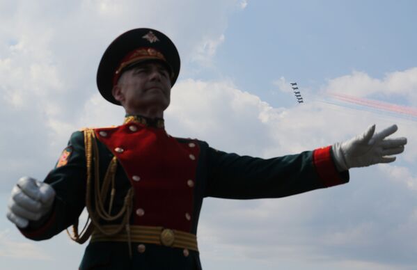 Membro de uma banda militar atua enquanto aviões de caça russos voam em formação durante o desfile do Dia da Marinha na cidade russa de Kronstadt, perto de São Petersburgo, 28 de julho de 2019 - Sputnik Brasil