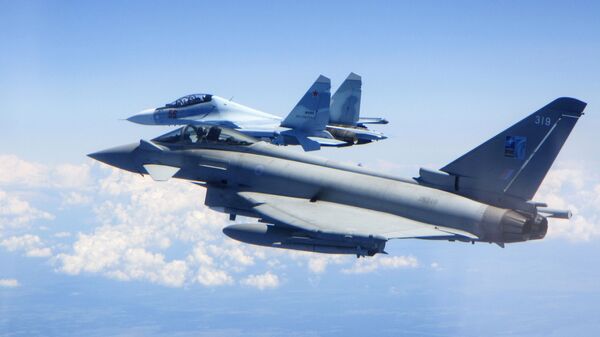 Caça Typhoon da Força Aérea do Reino Unido (em primeiro plano) segue um caça Su-30 Flanker russo - Sputnik Brasil