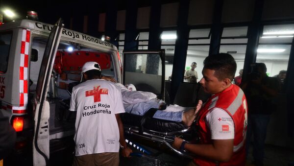 Membros da Cruz Vermelha hondurenha entram no Hospital Escola Universitário com um torcedor ferido durante o motim no Estádio Nacional Tiburcio Carías Andino, em Tegucigalpa, em 17 de agosto de 2019 - Sputnik Brasil