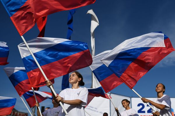 Meninas com bandeiras da Rússia na praça Karl Marx na cidade de Novosibirsk, na Rússia - Sputnik Brasil