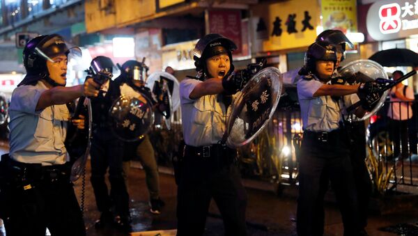Policiais apontam armas para manifestantes contra lei de extradição após embates em Tsuen Wan, em Hong Kong - Sputnik Brasil