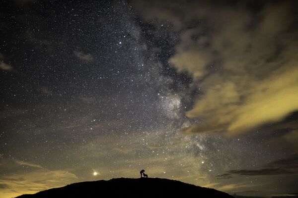 Imagem retrata o fotógrafo britânico Ben Bush, que ganhou o 1º lugar na categoria Pessoas e Espaço, na competição Insight Investment Astronomy Photographer of the Year 2019, cercado por Marte, Saturno e o núcleo galáctico da Via Láctea - Sputnik Brasil