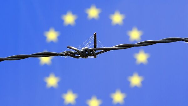 Arame farpado em frente à bandeira da União Europeia. - Sputnik Brasil