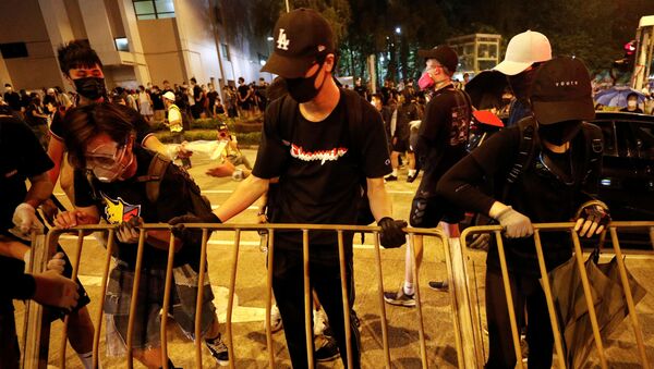 Manifestantes retiram uma grade do lado e fora do estádio Rainha Elizabeth, em Hong Kong, onde a chefe-executiva da região, Carrie Lam, realiza diálogos com membros das manifestações. - Sputnik Brasil
