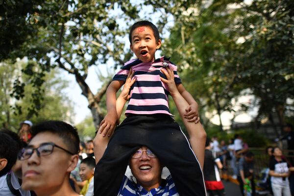 Pessoas observando o desfile militar dedicado ao 70º aniversário da fundação da República Popular da China, em Pequim - Sputnik Brasil