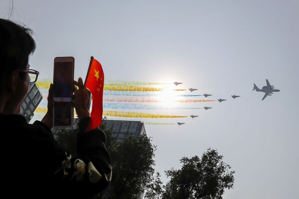 Homem tirando fotos dos aviões durante o desfile militar marcando o 70º aniversário da fundação da República Popular da China, em Pequim - Sputnik Brasil
