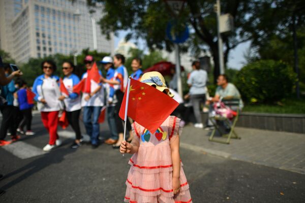 Menina com a bandeira da China durante o desfile militar marcando o 70º aniversário da fundação da República Popular da China, em Pequim - Sputnik Brasil