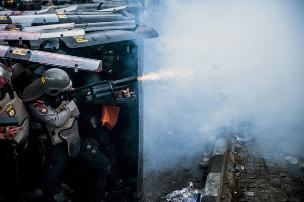 Policial usa gás lacrimogêneo durante confronto com manifestantes em Bandung, Indonésia - Sputnik Brasil